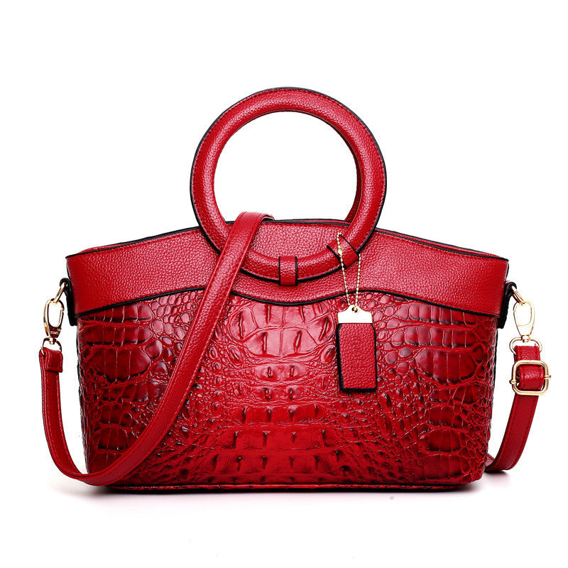 Stylish red casual ladies handbags with a unique crocodile texture and circular handles