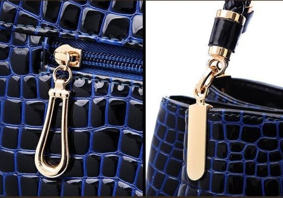 Close-up of MONO//FIT crocodile pattern bag with gold hardware and zipper detail