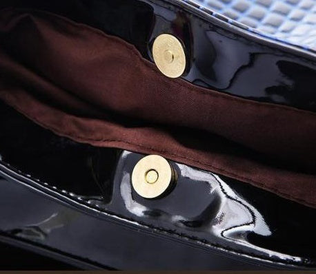 Close-up of the interior of a MONO//FIT crocodile pattern bag with gold snap buttons