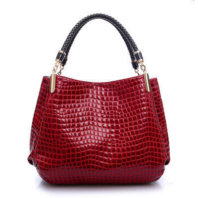 Red crocodile pattern bag with woven black handles for stylish everyday use