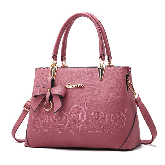 Elegant MONO//FIT fashionable women's handbag in pink with floral embossing and bow detail