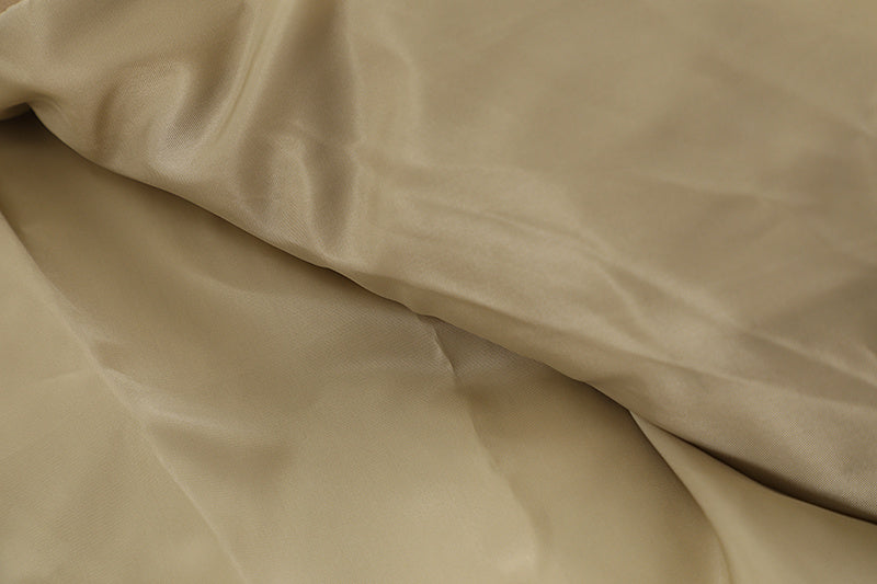 Soft beige fabric of a letter embroidered jacket by MONO//FIT featuring a smooth texture