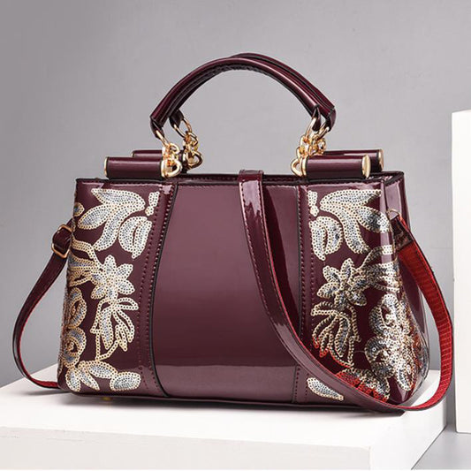 Elegant bridal party bag with intricate floral embroidery and a stylish design in deep burgundy color.