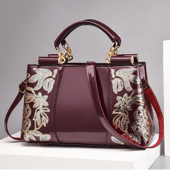 Elegant bridal party bag with intricate floral embroidery and a stylish design in deep burgundy color.