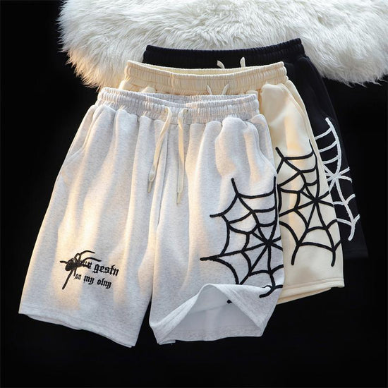 MONO//FIT embroidered spider shorts available in white, cream, and black designs with spider web details