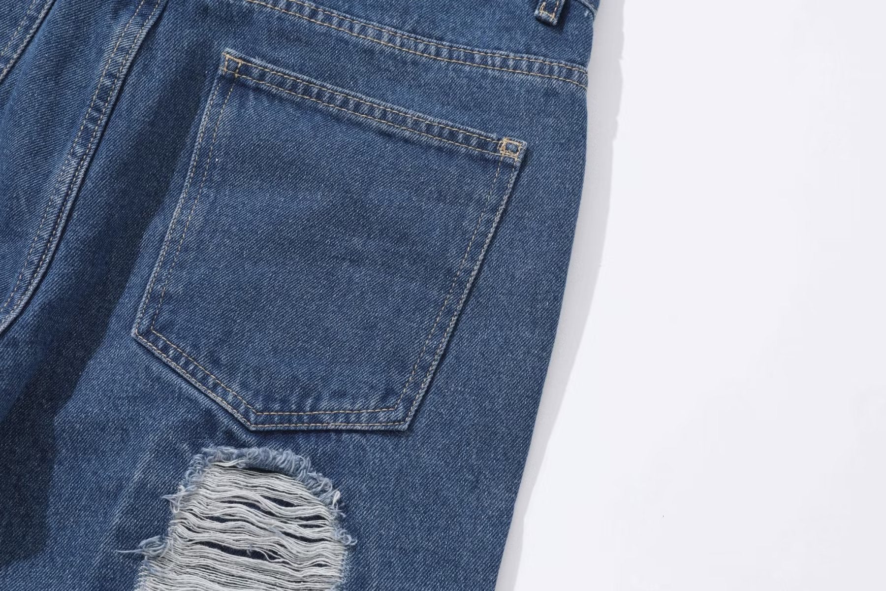 Close-up of MONO//FIT heavy industry style jeans with distressed details and classic denim blue color