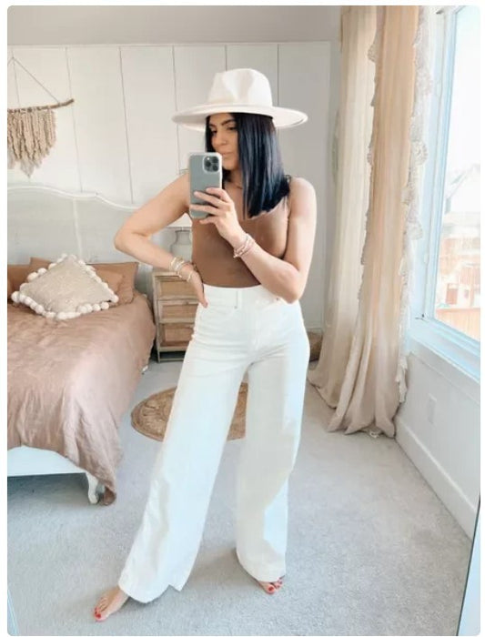 Chic model wearing MONO//FIT high waist wide leg jeans styled with a brown top and white hat