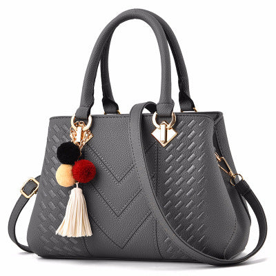 Elegant MONO//FIT luxury ladies handbags in gray leather with decorative tassels and vibrant pom poms