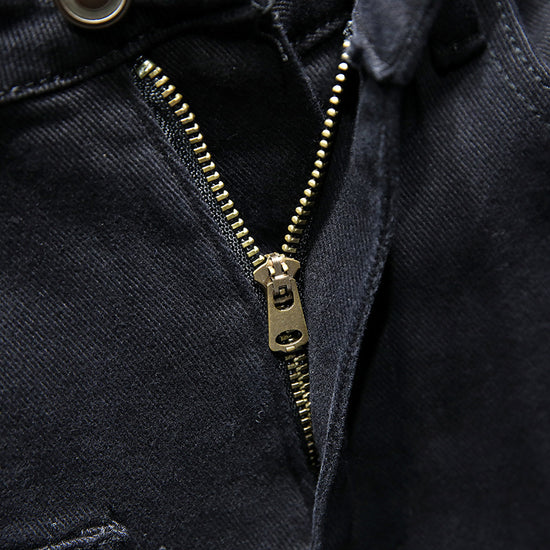 Close-up of MONO//FIT mens black ripped jeans showcasing the zipper detail and fabric texture