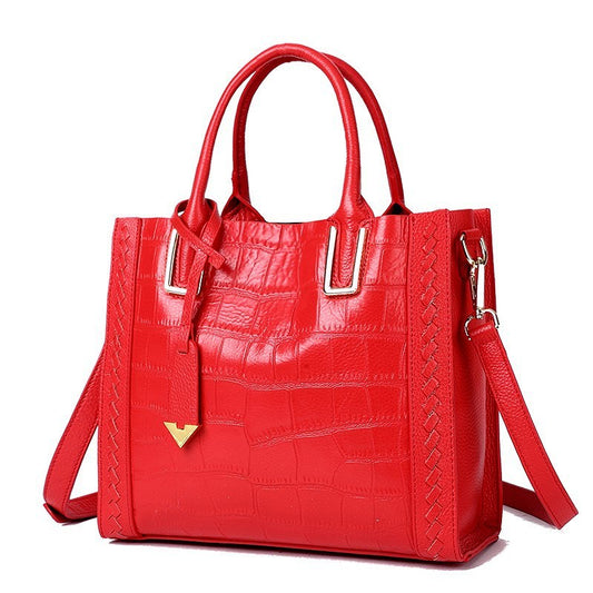 Red pattern woven leather handbag with dual handles and adjustable shoulder strap for stylish versatility
