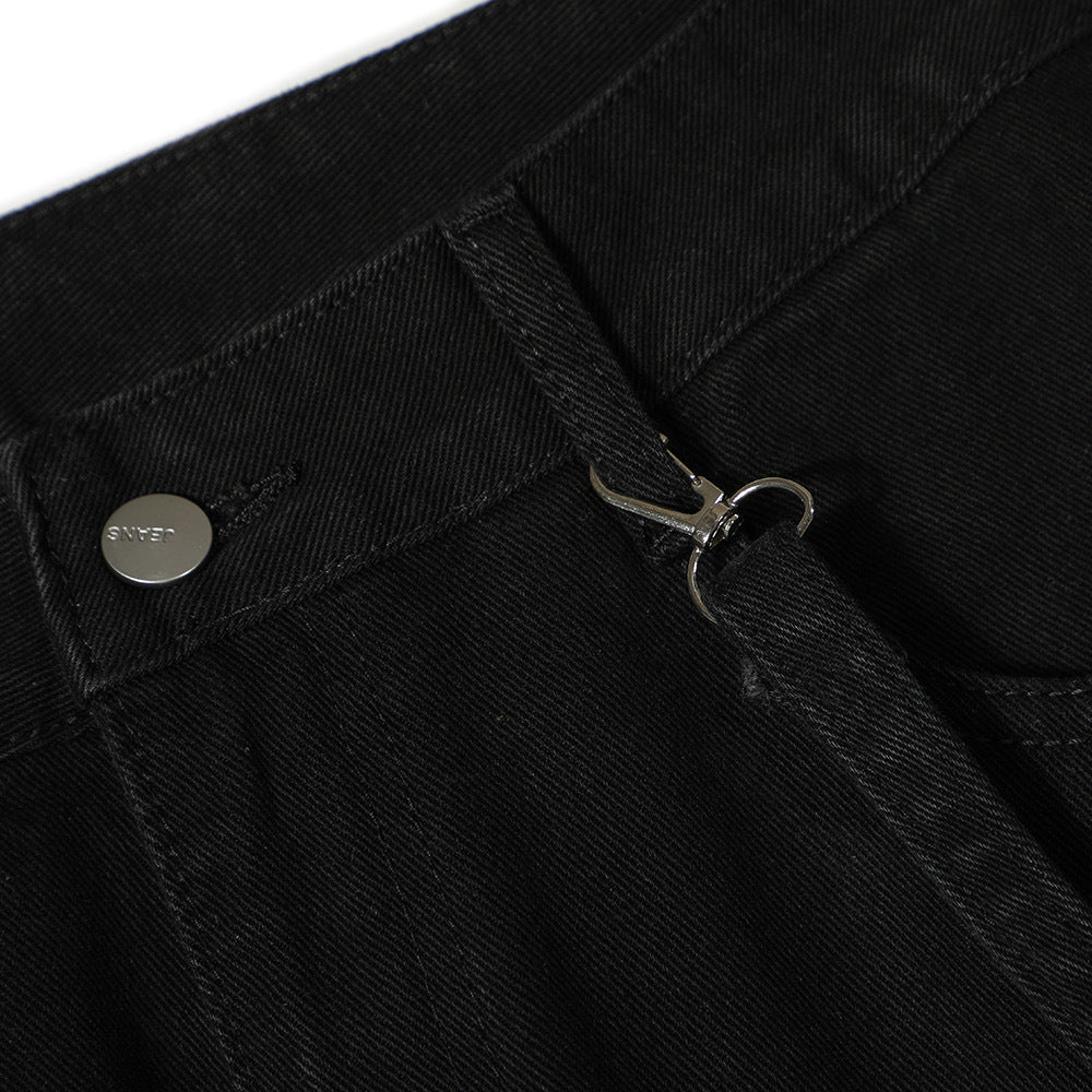 Close-up of MONO//FIT punk flared jeans men showing black fabric and metal button details