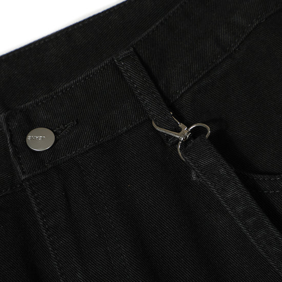Close-up of MONO//FIT punk flared jeans men showing black fabric and metal button details