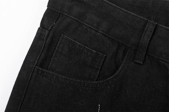 Close-up of MONO//FIT straight fit embroidered jeans showing pocket detail and black denim fabric