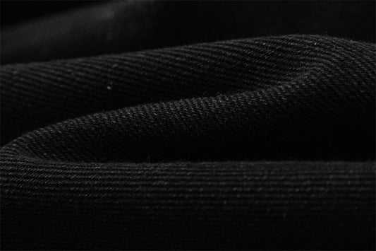 Close-up of MONO//FIT straight fit embroidered jeans showcasing textured black fabric