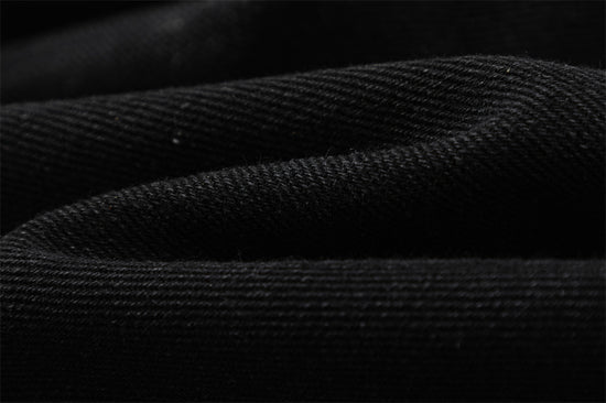 Close-up of MONO//FIT straight fit embroidered jeans showcasing textured black fabric