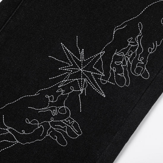 Close-up of MONO//FIT straight fit embroidered jeans featuring intricate hand design details