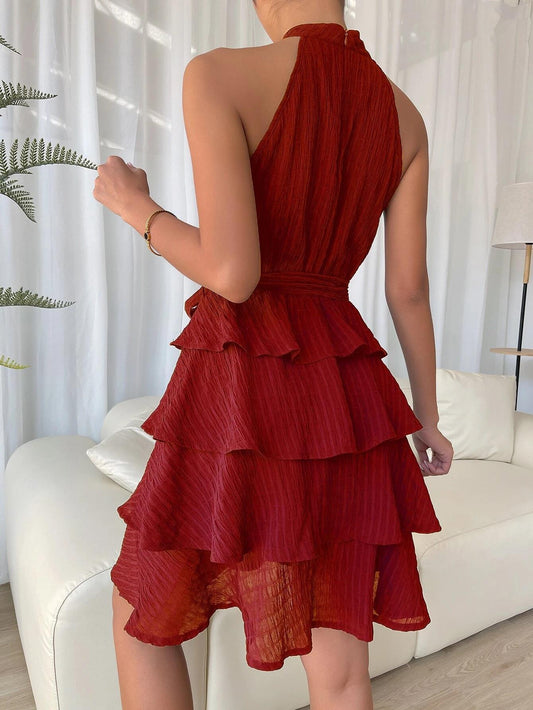 Back view of MONO//FIT women's halterneck ruffle dress in rich red with layered ruffles